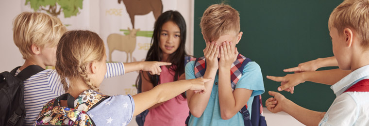 Niños señalando a un compañero triste