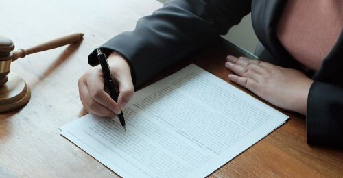 Persona escribiendo documentos legales