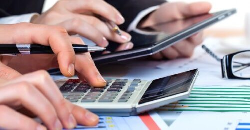 Manos trabajando con calculadora y tablet