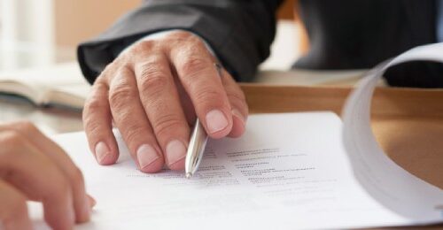 Mano firmando documentos importantes